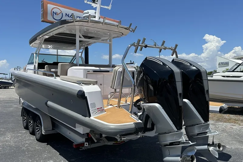 Slide: The Image of 2024 Axopar 37 Sun-Top boat with dual outboard engines on a trailer. - 8