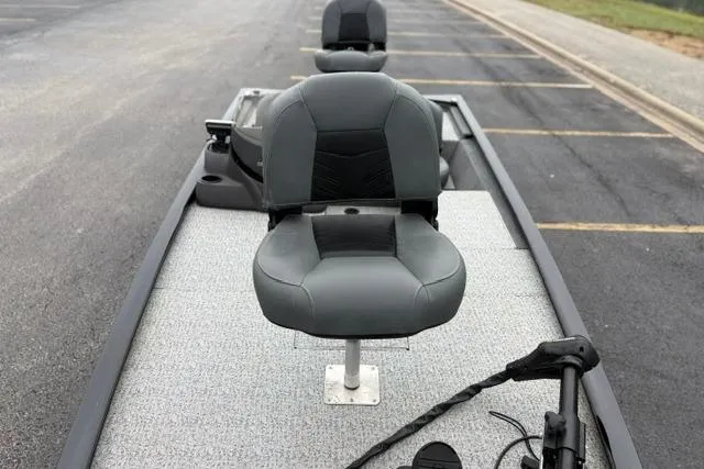 Slide: The Image of 2023 Tracker Pro 170 boat with gray seating on a paved surface. - 34