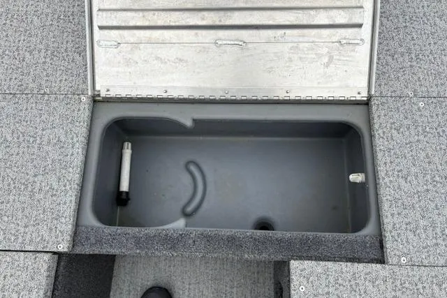 Slide: The Image of 2023 Tracker Pro 170 boat storage compartment with open lid, gray interior. - 37