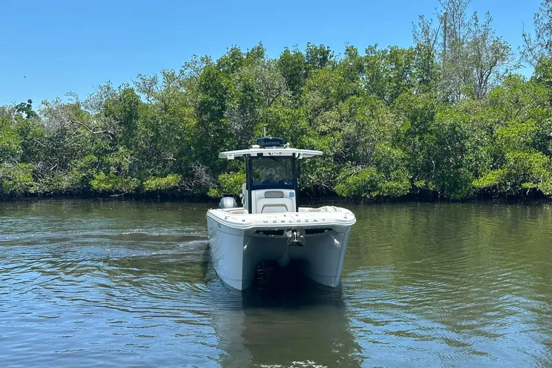 Slide: The Image of 2023 World Cat 280 CC-X boat navigating a calm river with lush greenery. - 14