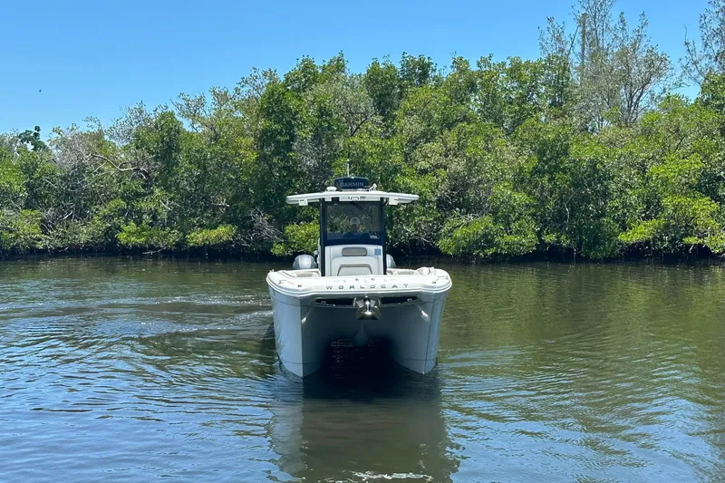Slide: The Image of 2023 World Cat 280 CC-X boat navigating a calm river with lush greenery. - 15