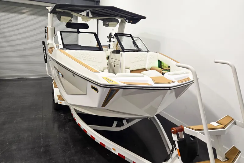 Slide: The Image of 2026 Nautique Super Air Nautique G23 Paragon boat on trailer in showroom. - 2