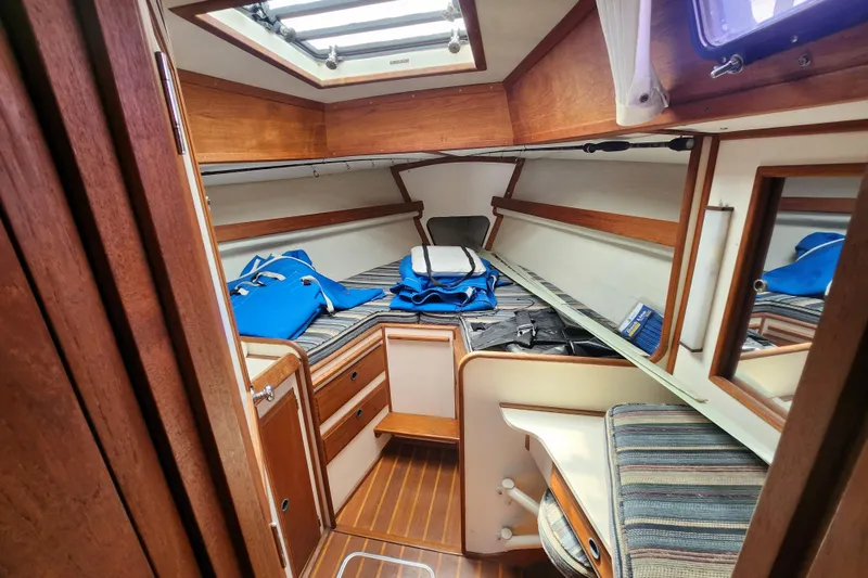 Slide: The Image of Cozy cabin interior of 1981 Columbia Yacht 10.7 with wooden accents and storage. - 10