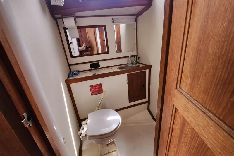 Slide: The Image of 1981 Columbia Yacht 10.7 bathroom with wooden cabinetry, sink, and mirror. - 11