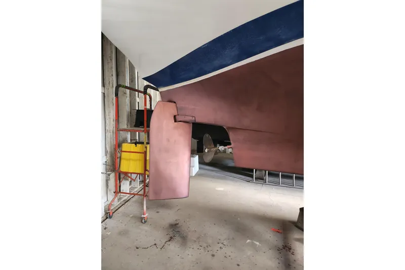Slide: The Image of 1978 Columbia Yacht 10.7 under maintenance, showcasing hull and rudder in a workshop. - 13