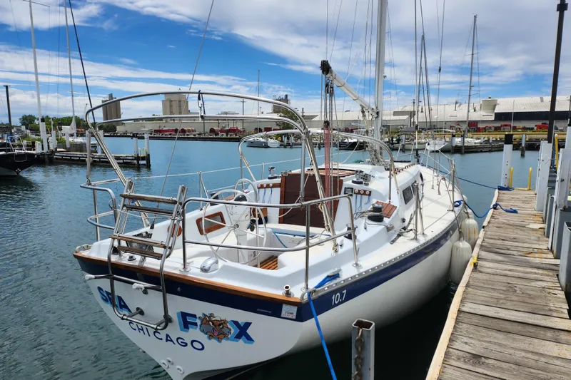 Slide: The Image of 1981 Columbia Yacht 10.7 docked in a marina, clear sky, calm water. - 2