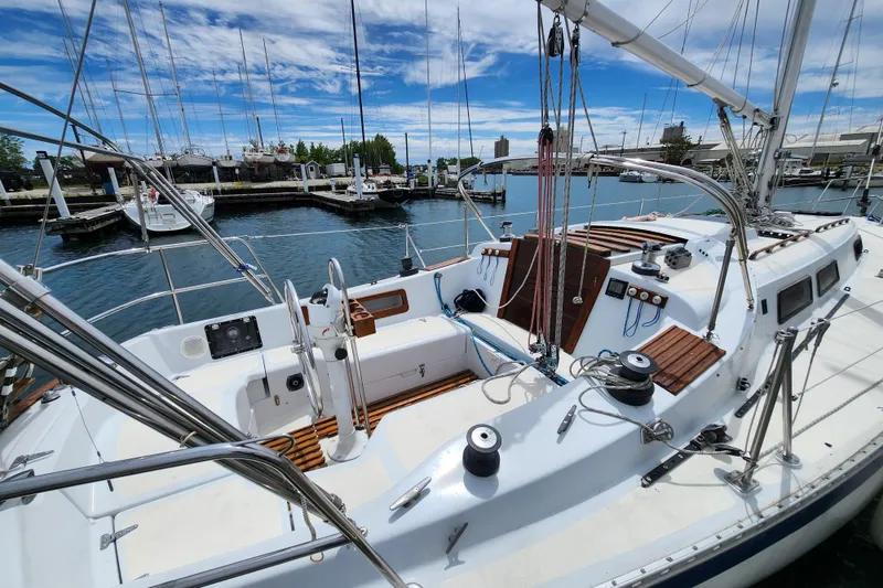 Slide: The Image of 1981 Columbia Yacht 10.7 in marina, showcasing spacious deck and sailing equipment. - 3