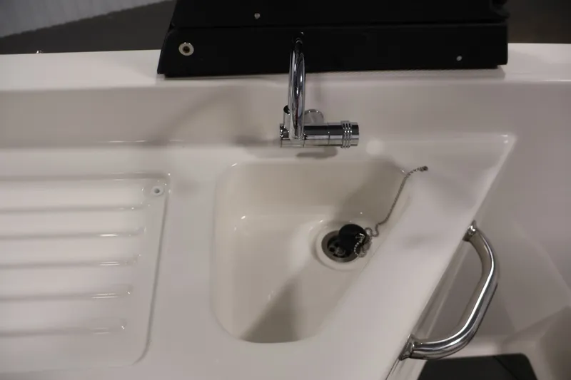 Slide: The Image of 2026 Bayliner D22I boat sink with chrome faucet and drain plug. - 31