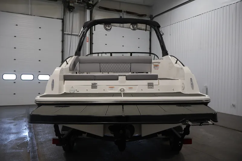 Slide: The Image of 2026 Bayliner D22I boat in a garage, rear view showcasing seating and deck. - 5