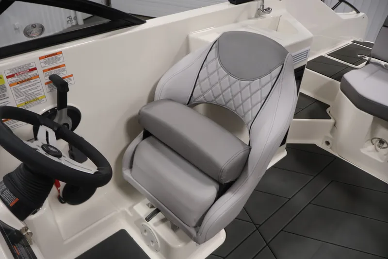 Slide: The Image of 2026 Bayliner D22I boat interior with steering wheel and cushioned seat. - 25