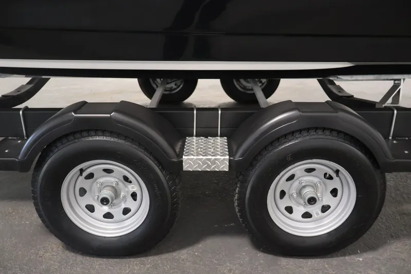 Slide: The Image of Trailer wheels of a 2026 Bayliner D22I boat, featuring dual axles and sturdy fenders. - 46