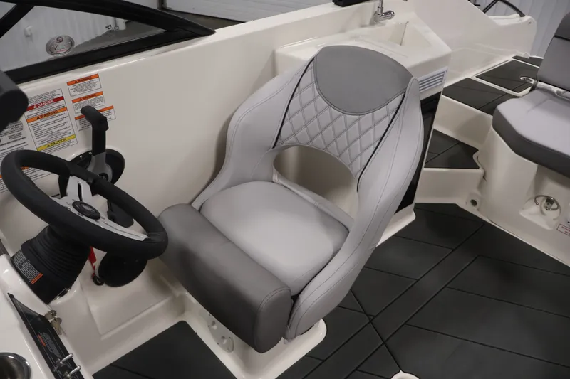 Slide: The Image of 2026 Bayliner D22I boat interior with steering wheel and cushioned captain's chair. - 24