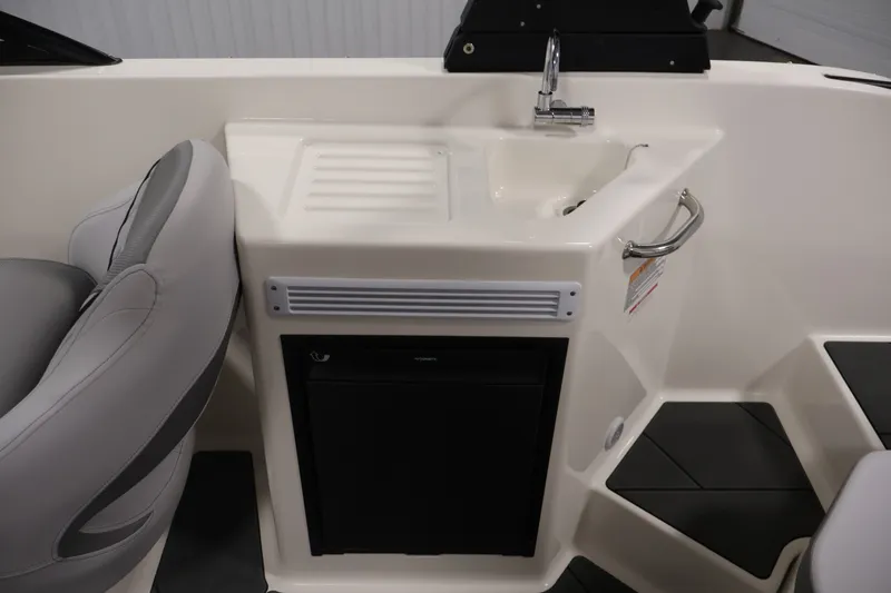 Slide: The Image of 2026 Bayliner D22I boat interior with sink and compact refrigerator. - 29