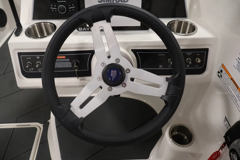 Slide: The Image of Steering wheel of 2026 Bayliner D22I boat with control panel and cup holders. - 17