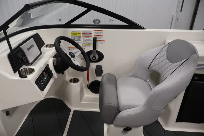 Slide: The Image of 2026 Bayliner D22I boat interior with steering wheel, control panel, and cushioned captain's chair. - 15