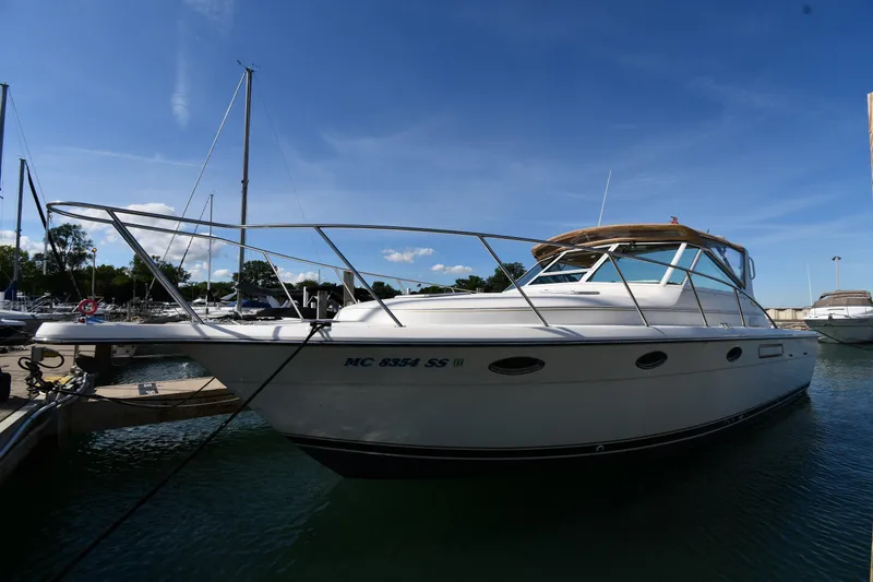 The Image of 1998 Tiara Yachts 3100 Open docked at marina under clear blue sky. - 1