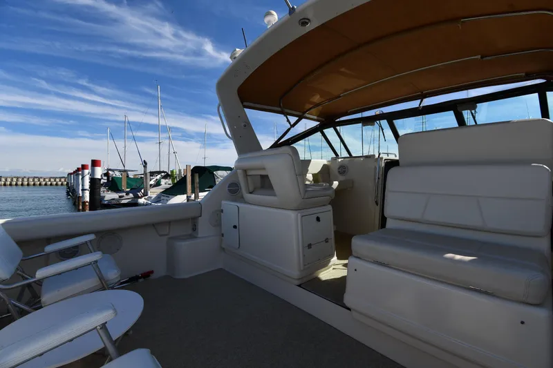 Slide: The Image of 1998 Tiara Yachts 3100 Open interior with seating, docked at marina under blue sky. - 16
