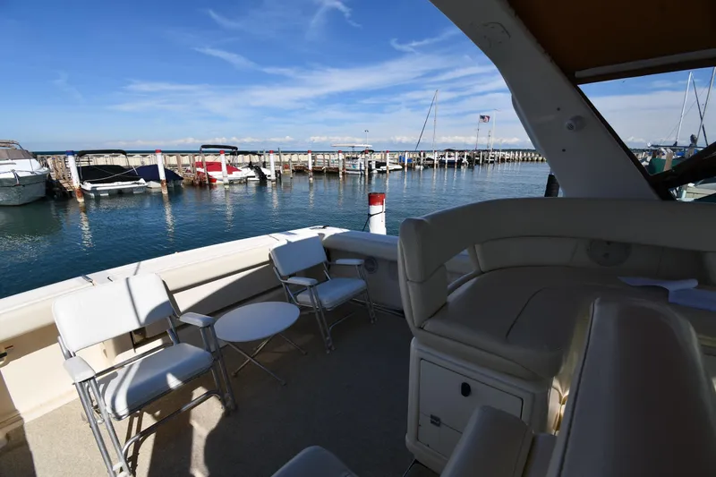 Slide: The Image of 1998 Tiara Yachts 3100 Open docked, featuring spacious seating and scenic marina view. - 17
