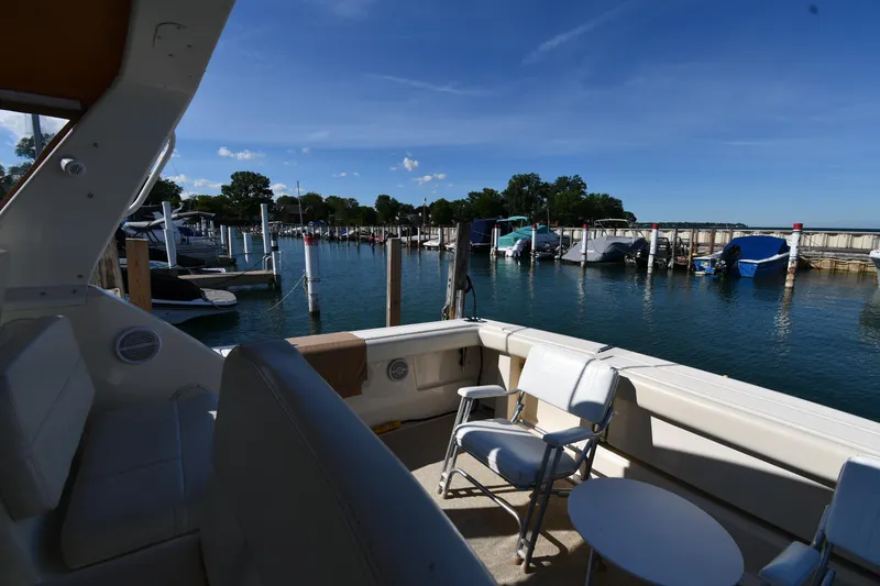 Slide: The Image of 1998 Tiara Yachts 3100 Open at marina, featuring spacious deck and scenic waterfront view. - 18