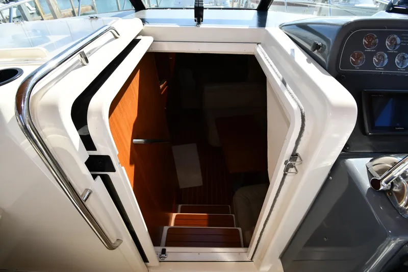 Slide: The Image of Cabin entrance of 1998 Tiara Yachts 3100 Open, featuring wooden steps and sleek interior design. - 19