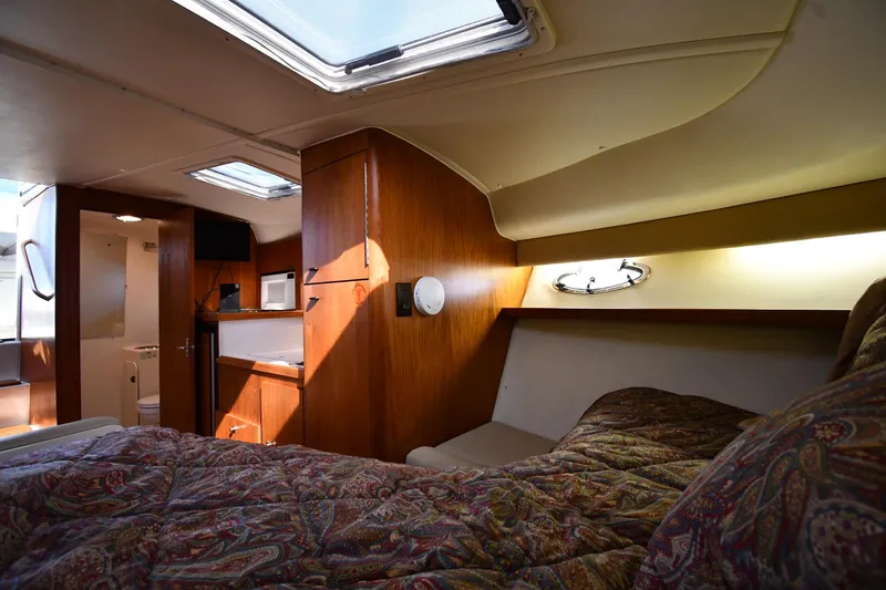 Slide: The Image of Cozy cabin interior of 1998 Tiara Yachts 3100 Open with wood finish and bedding. - 21