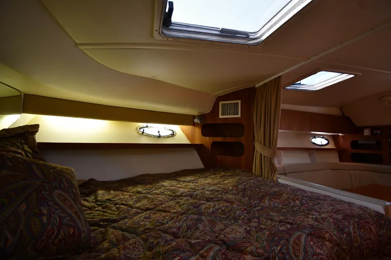 Slide: The Image of Cozy cabin interior of 1998 Tiara Yachts 3100 Open with patterned bedding and porthole windows. - 22