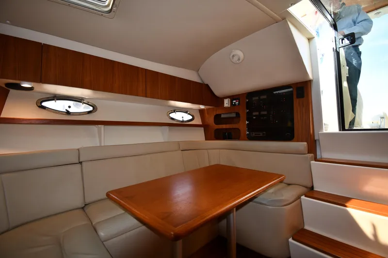 Slide: The Image of Interior of 1998 Tiara Yachts 3100 Open, featuring a cozy seating area and wooden table. - 26