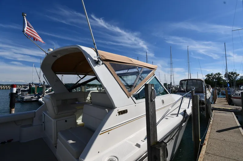 Slide: The Image of 1998 Tiara Yachts 3100 Open docked at marina under clear blue sky. - 3