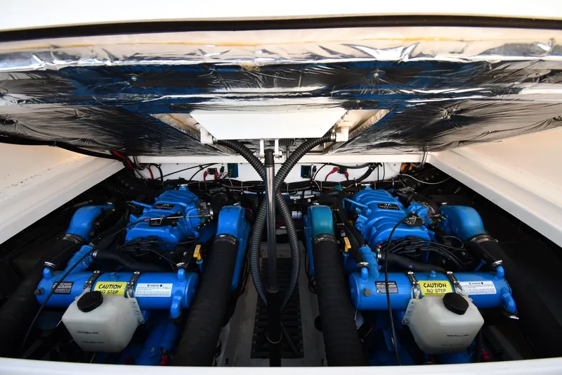 Slide: The Image of Engine compartment of a 1998 Tiara Yachts 3100 Open, featuring dual blue engines. - 35