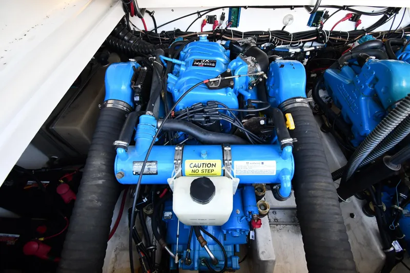 Slide: The Image of Engine compartment of a 1998 Tiara Yachts 3100 Open, featuring blue marine engines. - 37