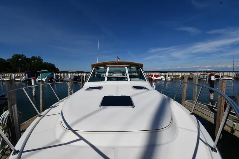Slide: The Image of 1998 Tiara Yachts 3100 Open docked at marina under clear blue sky. - 5