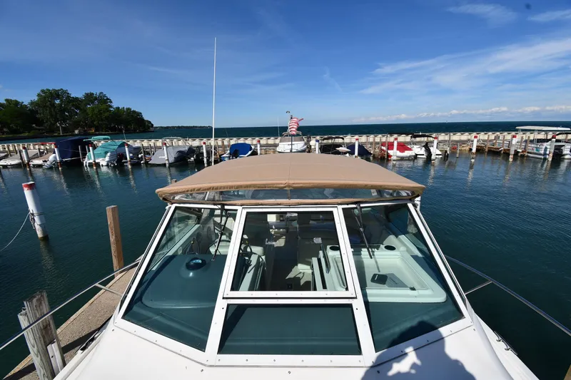 Slide: The Image of 1998 Tiara Yachts 3100 Open docked at marina under clear blue sky. - 6