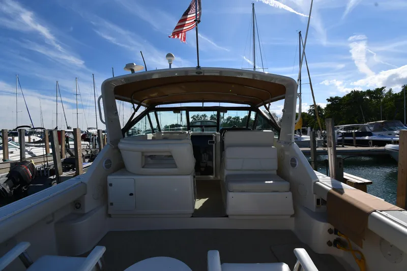 Slide: The Image of 1998 Tiara Yachts 3100 Open at marina, featuring spacious cockpit and American flag. - 7
