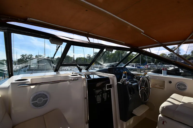 Slide: The Image of 1998 Tiara Yachts 3100 Open cockpit with steering wheel and marina view. - 8