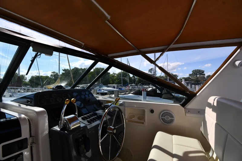 Slide: The Image of 1998 Tiara Yachts 3100 Open helm with steering wheel and controls, docked at marina. - 9