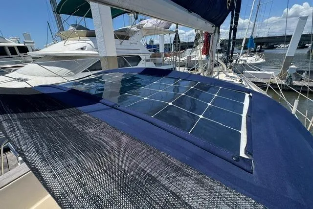 Slide: The Image of Solar panels on a 1997 Island Packet 37 sailboat docked at a marina. - 12