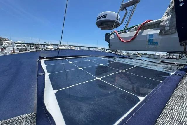 Slide: The Image of 1997 Island Packet 37 sailboat with solar panel on deck, docked at marina. - 13