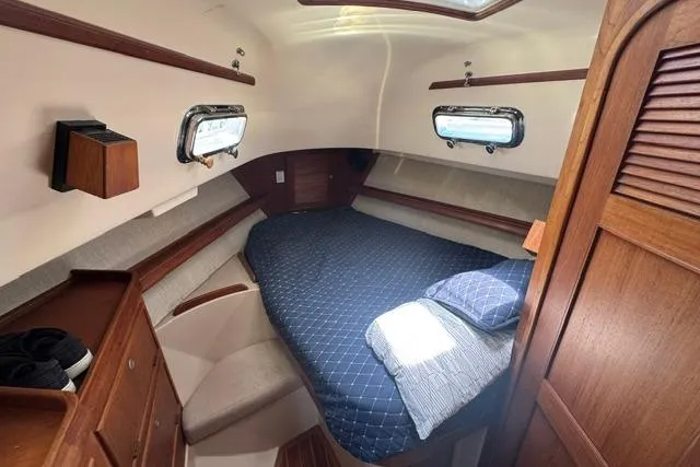 Slide: The Image of Cozy cabin interior of a 1997 Island Packet 37 sailboat with a comfortable bed. - 18
