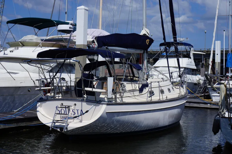 Slide: The Image of 1997 Island Packet 37 sailboat docked at marina under blue sky. - 3