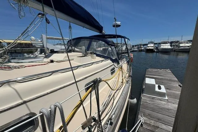 Slide: The Image of 1997 Island Packet 37 sailboat docked at marina under clear blue sky. - 4