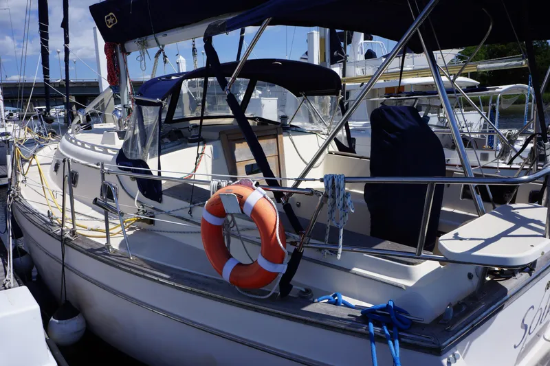 Slide: The Image of 1997 Island Packet 37 sailboat docked with lifebuoy and covered cockpit. - 5