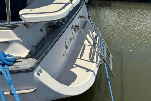 Slide: The Image of 1997 Island Packet 37 sailboat stern with swim ladder and blue mooring lines. - 7