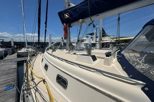 Slide: The Image of 1997 Island Packet 37 sailboat docked at marina under clear blue sky. - 9