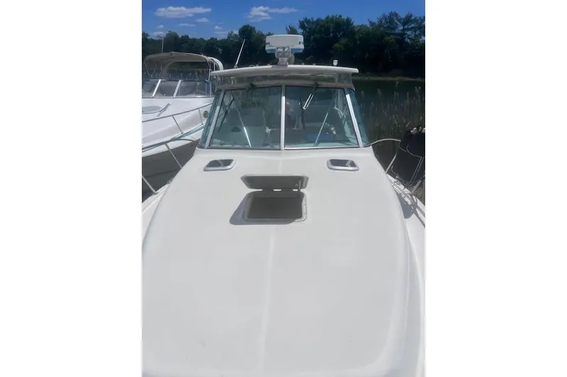 Slide: The Image of 2003 Pursuit 3000 Express boat docked under clear blue sky. - 14