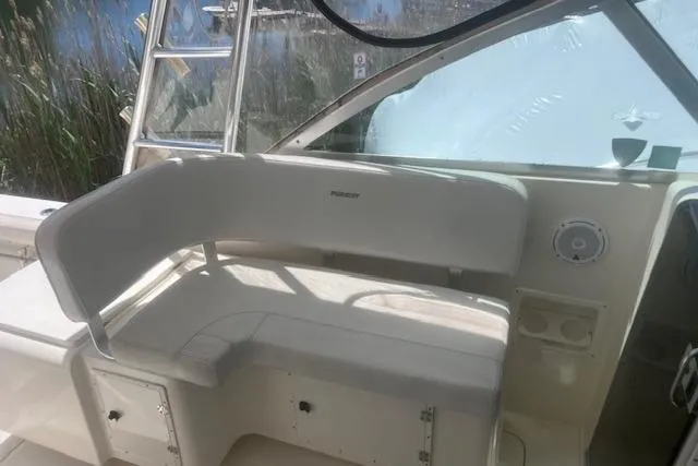 Slide: The Image of 2003 Pursuit 3000 Express boat interior with white seating and helm area. - 16