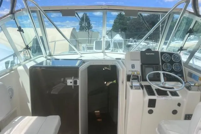 Slide: The Image of 2003 Pursuit 3000 Express boat cockpit with steering wheel and navigation instruments. - 18