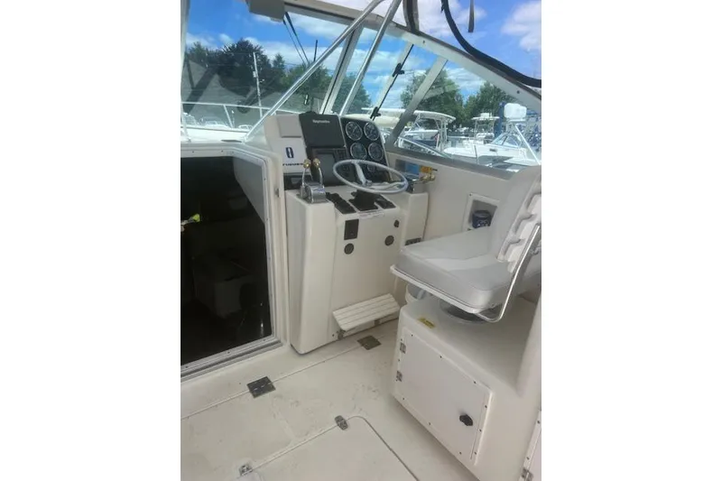 Slide: The Image of Helm of 2003 Pursuit 3000 Express boat with steering wheel and control panel. - 19