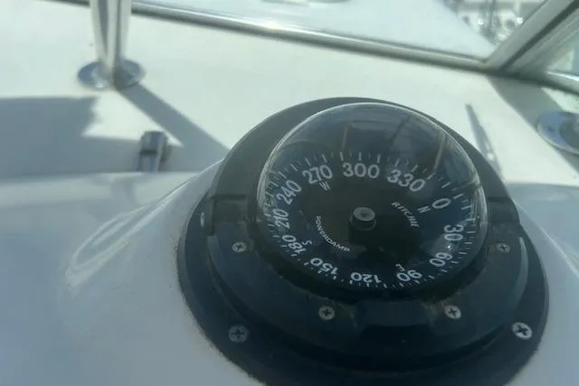 Slide: The Image of Compass on 2003 Pursuit 3000 Express boat dashboard, showing navigation directions. - 21