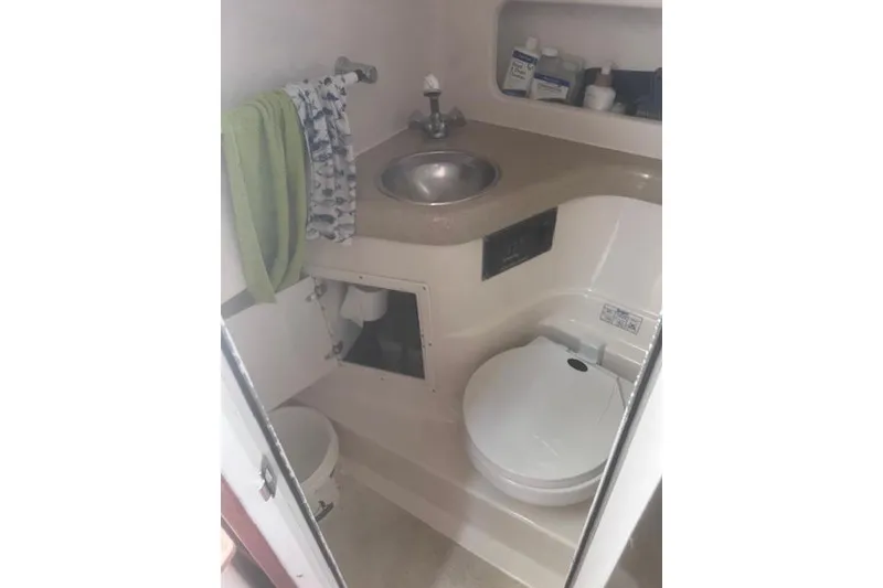 Slide: The Image of Compact bathroom in a 2003 Pursuit 3000 Express boat with sink and toilet. - 27
