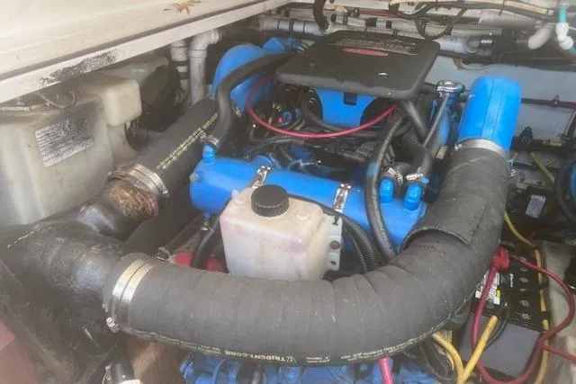 Slide: The Image of Engine compartment of a 2003 Pursuit 3000 Express boat, featuring hoses and components. - 36